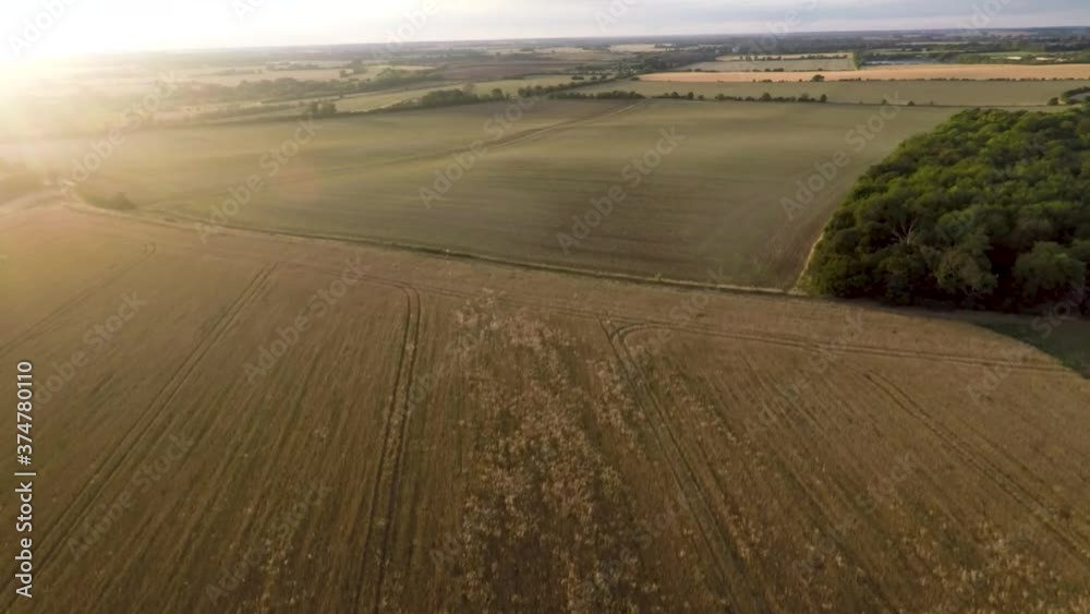 Flying over a farmer field with the beautiful glow of a stunning golden sunset. Flying over a farmer field with the beautiful glow of a stunning golden sunset.