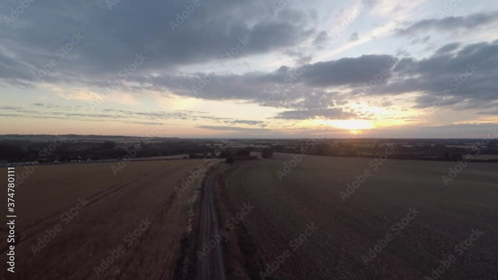 Slowly flying up over a farmers field to reveal a beautiful golden sunset. Slowly flying up over a farmers field to reveal a beautiful golden sunset.