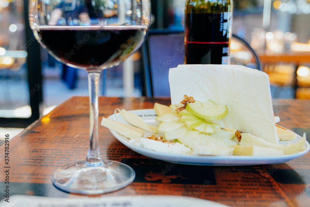 Fototapeta premium red wine in a glass with fruit appetizer