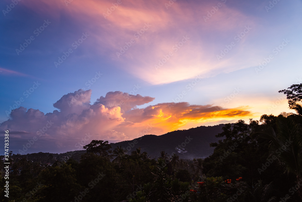 Obraz premium Spectacular sunset sky over valley with trees, city and mountains. View from the top.