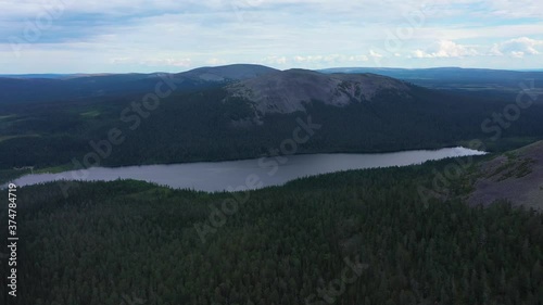 Aerial view tilting towards lake Kesankijarvi and the Kesanki fell, on a gloomy, summer day, in Pallas-Yllastunturi national park, Kolari, Lapland, Finland - tracking, drone shot photo