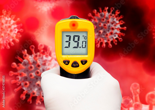 Hand holding a thermometer on red corona virus illustration background. 