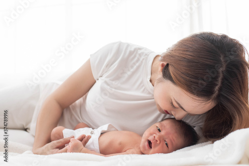 woman and new born boy relax. mother breast feeding baby. family at home. happy mother and baby. young mother holding her newborn child. mom nursing baby. mother and baby child on a white bed.
