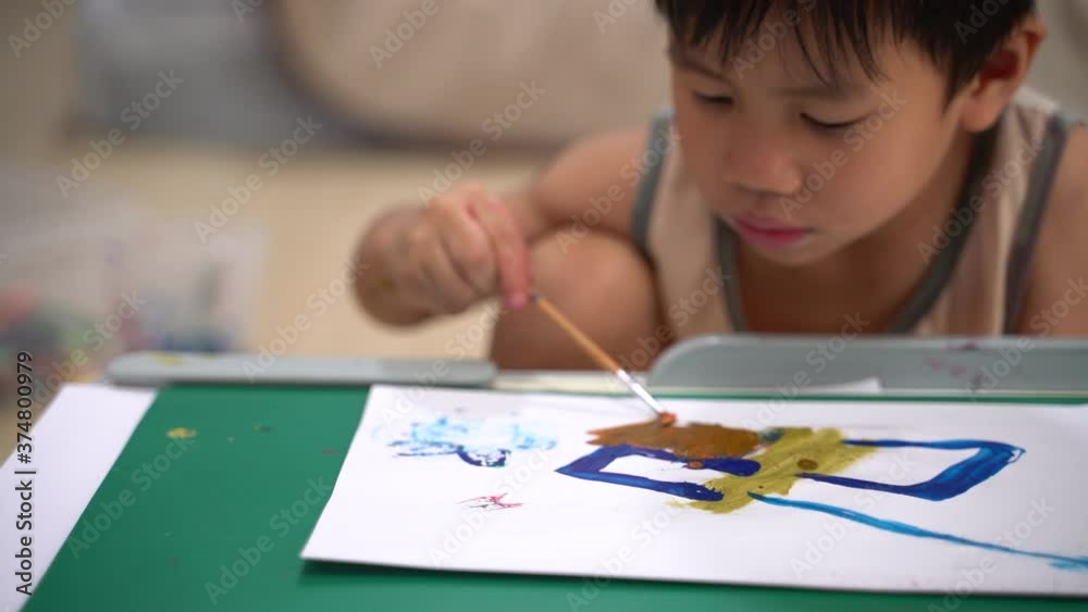 Asian boy about 4 years old painting picture with watercolor and brush as study at home Asian boy about 4 years old painting picture with watercolor and brush as study at home