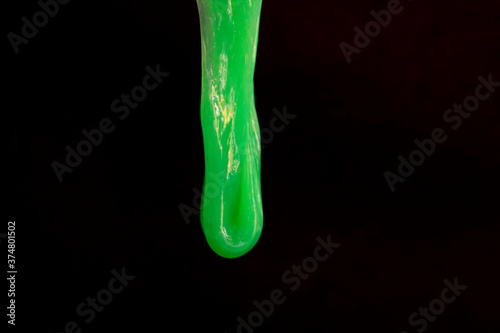 A drop of green slime runs down the black wall. Halloween decor. Space for text, copy space. The photo