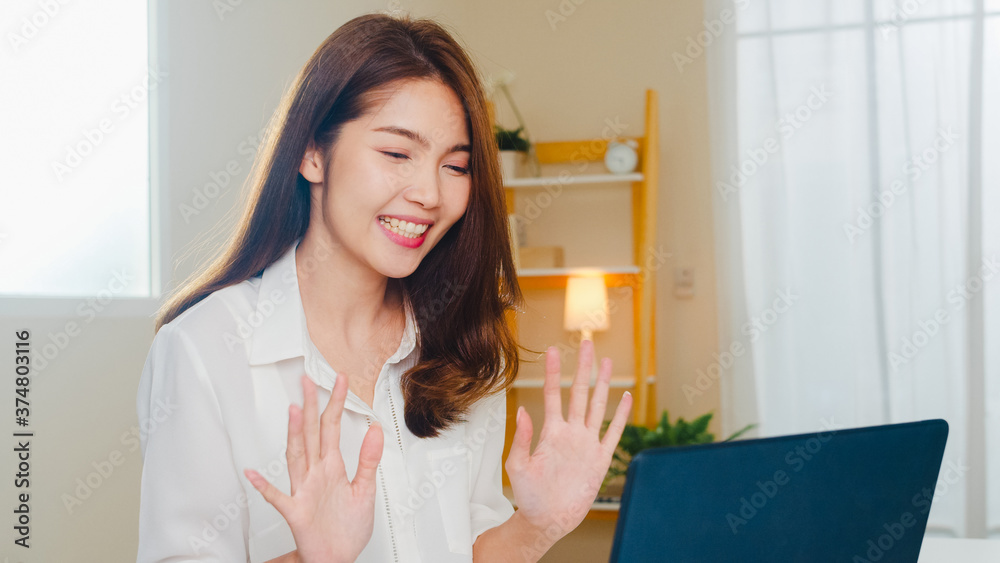 Young Asian business female using laptop video call talking with couple while working from home at living room. Self-isolation, social distancing, quarantine for coronavirus in next normal concept. Young Asian business female using laptop video call talking with couple while working from home at living room. Self-isolation, social distancing, quarantine for coronavirus in next normal concept.