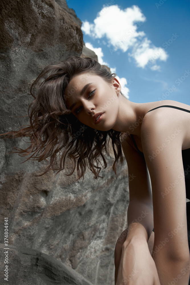 Beautiful girl in a black dress poses near the sand mountains. Fashion woman in nature, beautiful makeup and hairstyle Beautiful girl in a black dress poses near the sand mountains. Fashion woman in nature, beautiful makeup and hairstyle
