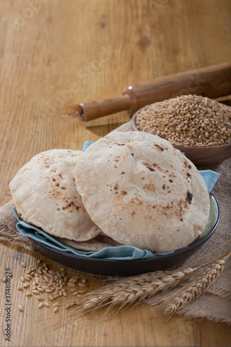 Indian bread (Roti) on a wooden base along with the props. photo