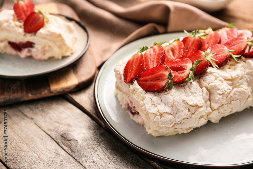 Delicious meringue roll with strawberry on plate Delicious meringue roll with strawberry on plate