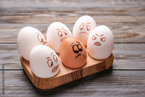 Foto Chicken eggs with drawn faces on wooden background