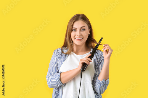 Young woman with curling ir...