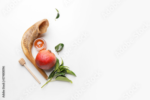 Honey with pomegranate and shofar on white background. Rosh Hashanah (Jewish New Year) celebration photo