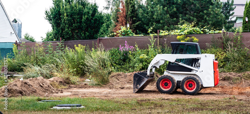 Fotografi A skid steer loader clears the site for construction