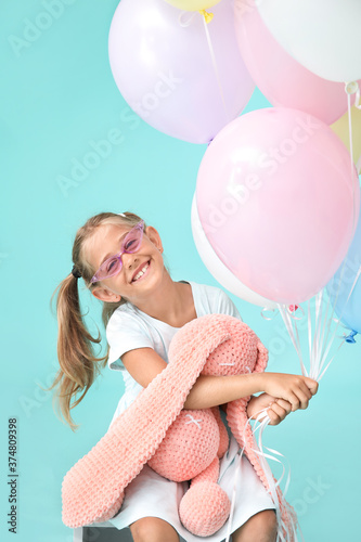 Little girl with balloons a...