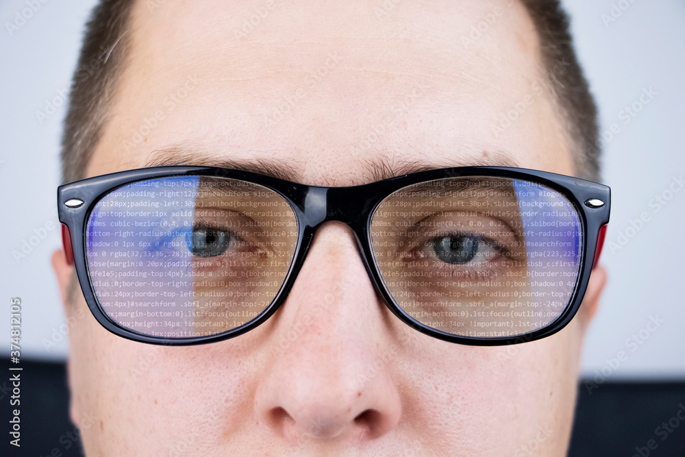 The programmer's glasses reflect lines of code. Programming, development of applications, sites and other things. Software development concept The programmer's glasses reflect lines of code. Programming, development of applications, sites and other things. Software development concept