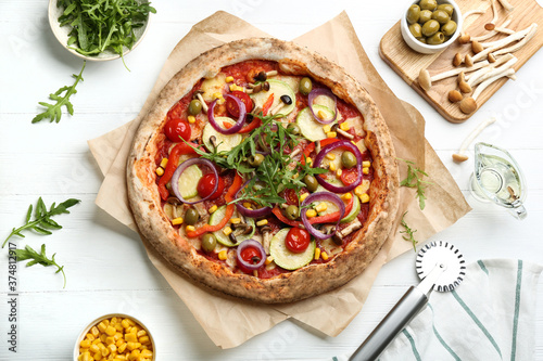 Flat lay composition with vegetable pizza on white wooden table