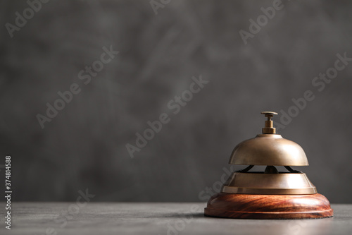 Hotel service bell on grey table. Space for text