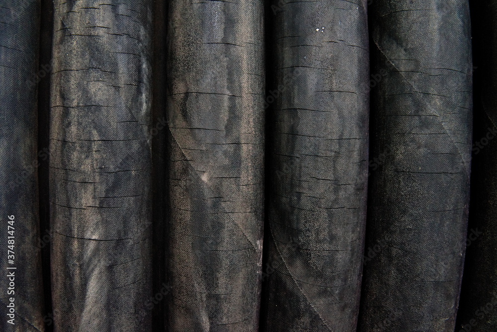 Fototapeta premium Cracked worn rubber hoses in a coil. Close-up.
