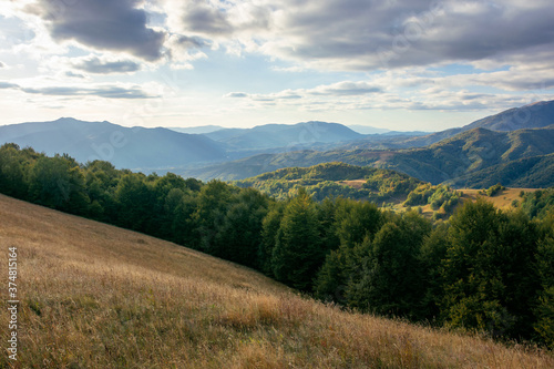 mountainous countryside in the afternoon. beautiful landscape of carpathians. valley of borzhava ridge in the distance. clouds on the sky. sunny weather