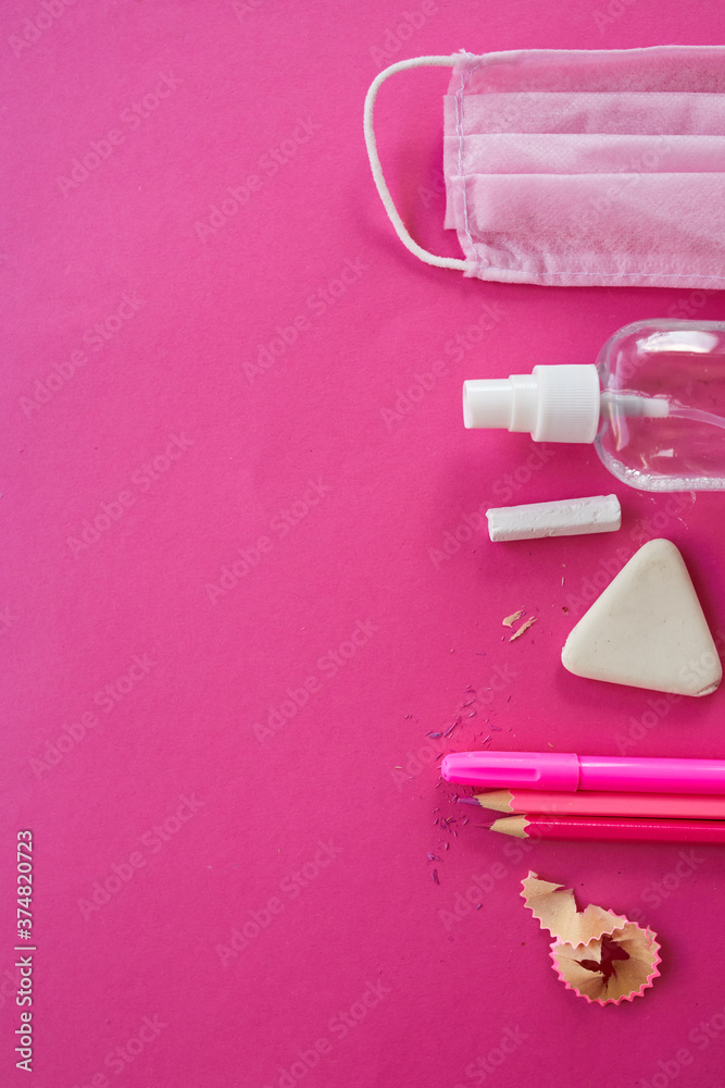 Flat lay schooling after the coronavirus pandemic, Back to school in a new reality, School supplies, protective mask and antiseptic on a pink background, space for text.. Flat lay schooling after the coronavirus pandemic, Back to school in a new reality, School supplies, protective mask and antiseptic on a pink background, space for text..