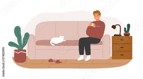 Relaxed man in warm sweater sitting on couch with hot beverage vector flat illustration. Smiling male spending time at living room coziness interior isolated. Happy guy resting on sofa with cat