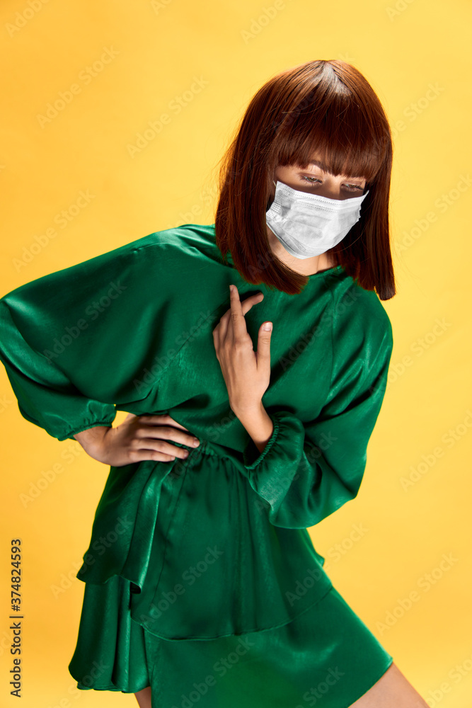 Woman in fashion dress posing in medical mask virus covid-19