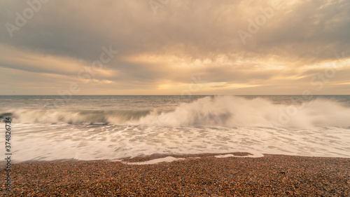 Sunset beach landscape photo with the crashing waves on Chisel Beach on the English south coast.  This is also known as the Jurassic Coastline.