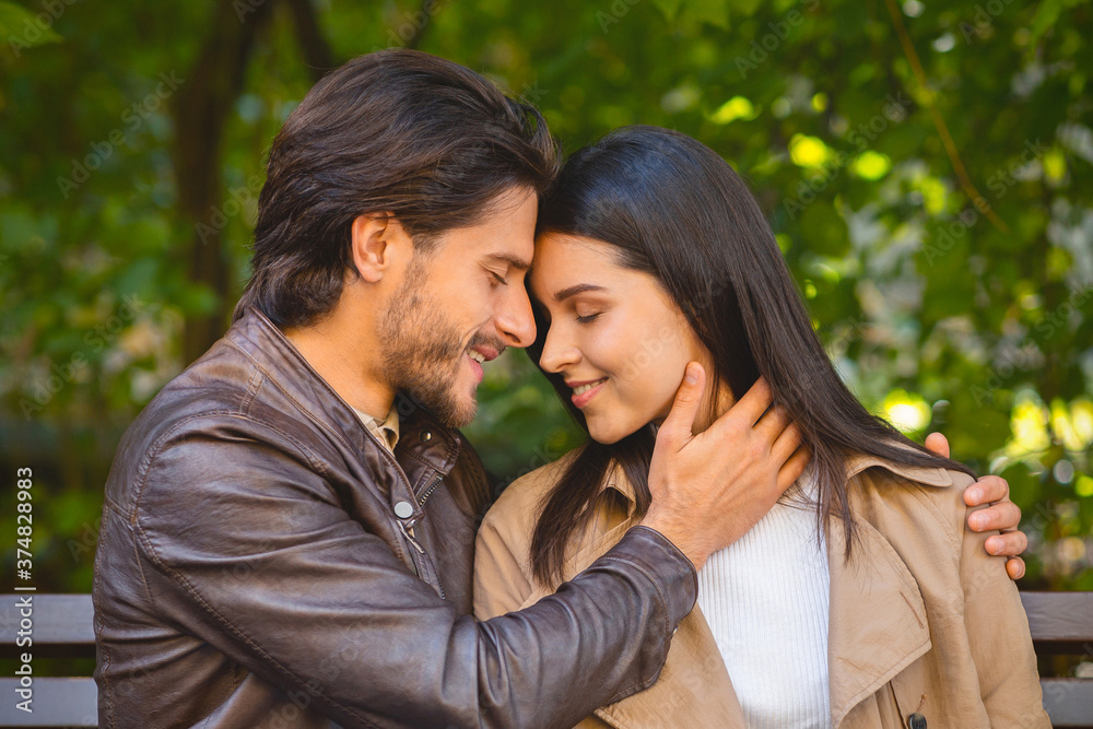 Portrait of beautiful couple cuddling in park