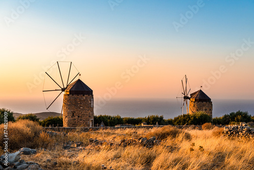 Two windmills in the mountains at golden hour sunset