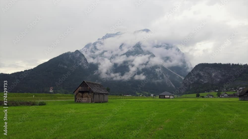 passing through a meadow and in the background there is a mountain with clouds passing through a meadow and in the background there is a mountain with clouds