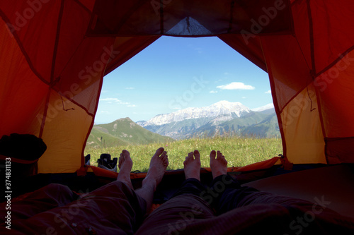 View from tent to the mountain. Sports and outdoor activities. First-person view from the tent.