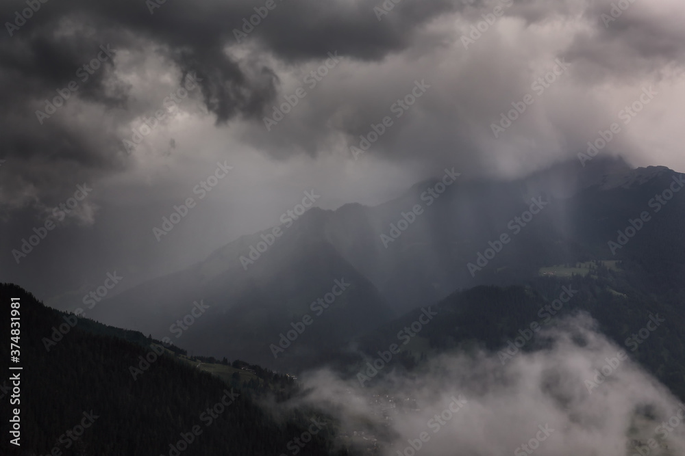 dramatic storm clouds over mountains in summer