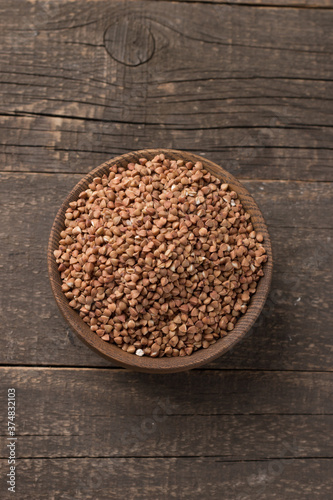 Buckwheat groats on wooden background. Healthy cereal concept.  