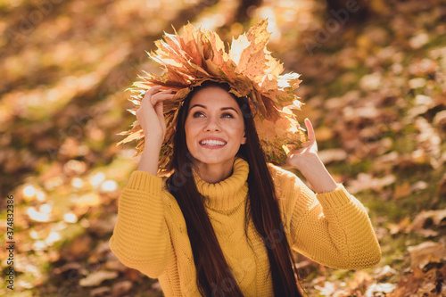 Autumn september atmosphere concept. Pretty charming girl have forest woodland nature relax enjoy warm hot sunlight sunshine wear knitted sweater pullover wreath maple leaves