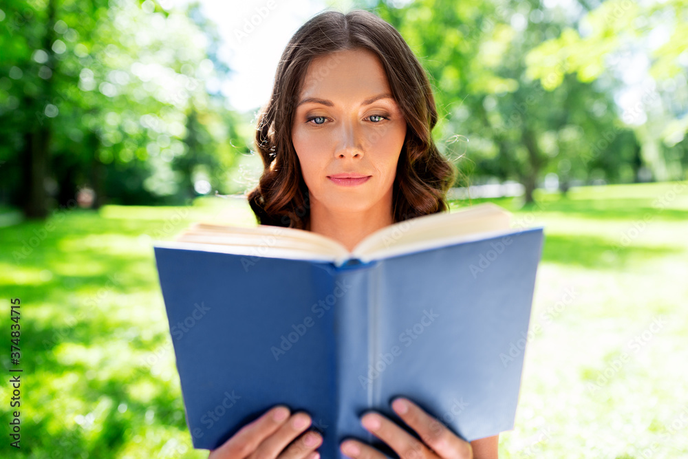 leisure and people concept - beautiful young woman reading book at summer park leisure and people concept - beautiful young woman reading book at summer park