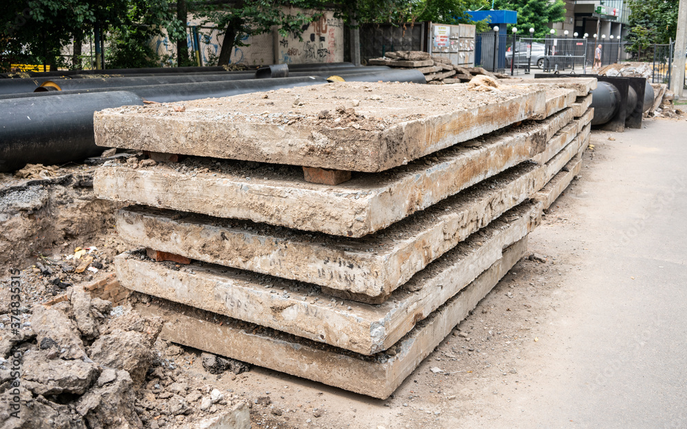 Insulated huge pipes and concrete slabs on city road. Insulated huge pipes and concrete slabs on city road.