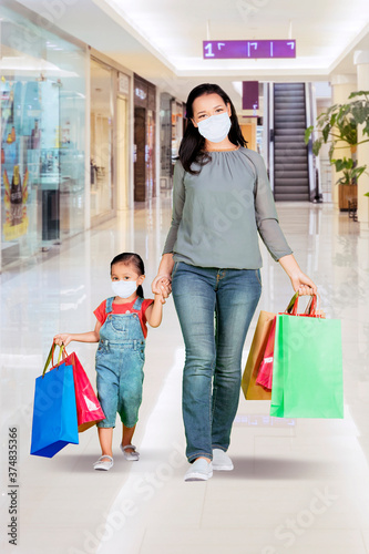 Mother and child wear mask while shopping in mall