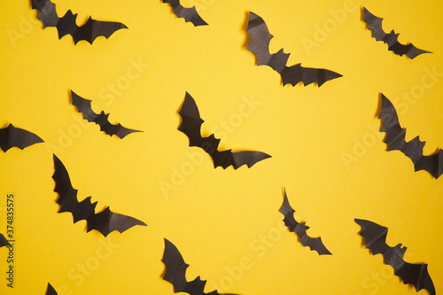 Halloween decoration concept black paper bats yellow cardboard background