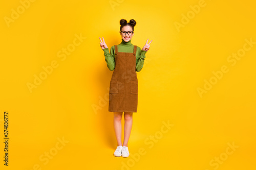 Full length photo of satisfied content girl enjoy weekend rest relax make v-sign wear green jumper skirt overall isolated over shine color background
