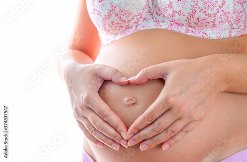 Wallpaper Mural Pregnant woman feeling happy at home while taking care of her child. The young expecting mother holding baby in pregnant belly. Maternity prenatal care and woman pregnancy concept. Torontodigital.ca