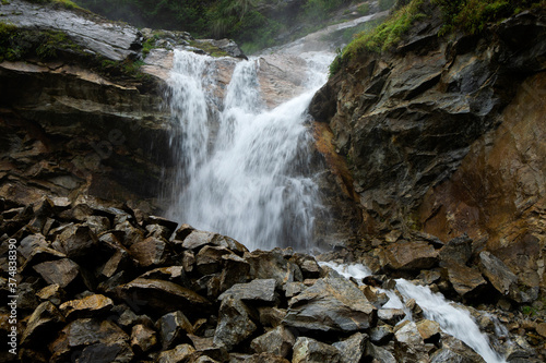 A water falls from a high cliff in a rocky forest in Himalaya in Sikkim in India
