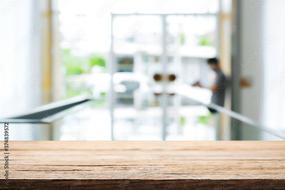 Empty wooden desk space and blurry background of home window for product display montage.