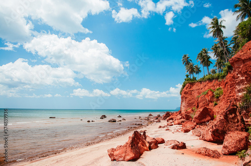 Tropical island red cliff rock beach with blue sky and clouds in summer, tranquil serene ocean scenery. Fang Daeng in Prachuap Khiri Khan. Thailand