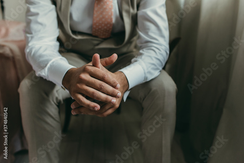 close up of man hands with suit and tie, sitting. Meditation concept, groom or businessman.