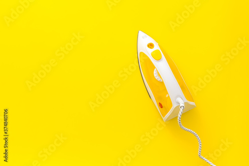 Top view of yellow iron on ironin board photo