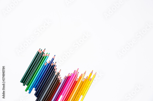Colored pencils isolated on white background in the corner with free place for text. Banner of the creative development and education of preschoolers, schoolchildren and adults. Art stationery
