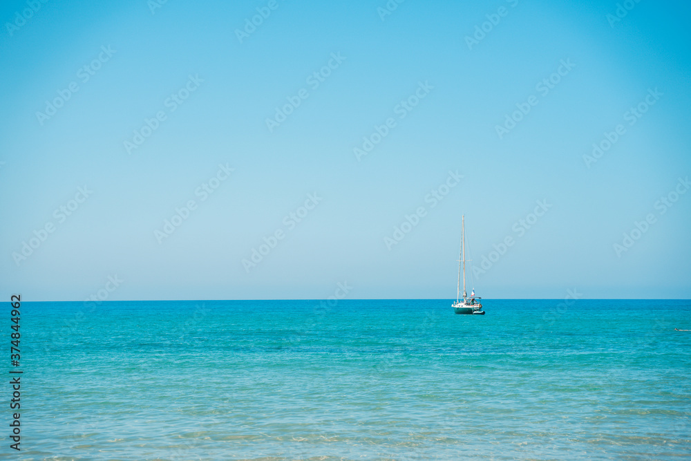 Bellissimo paesaggio marino con barca a vela all'orizzonte.