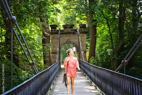 Woman in red dress walking on the bridge, Decin castle in Bohemia photo