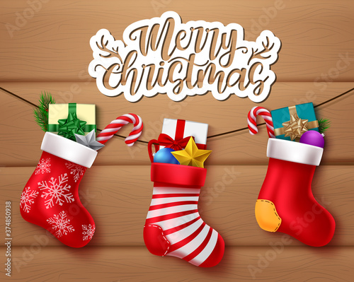 Merry christmas vector banner design. Merry christmas greeting text with hanging santa socks and xmas decoration element for holiday celebration. Vector illustration