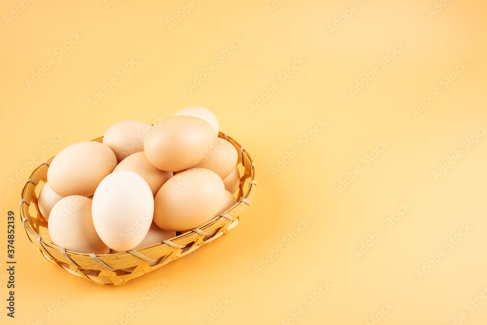 Eggs in a bamboo basket on yellow background